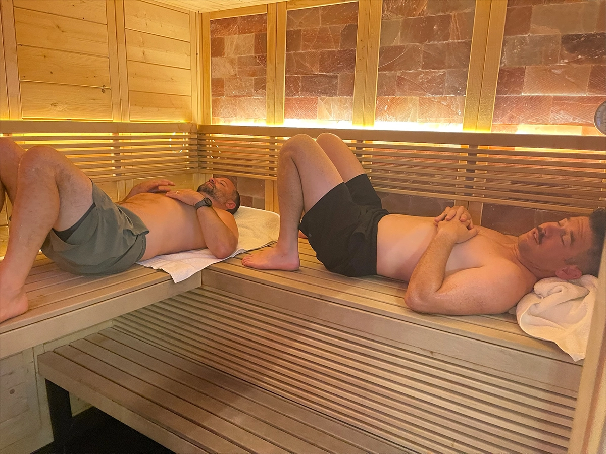Two men resting on the cedar benches of the R3 Contrast sauna
