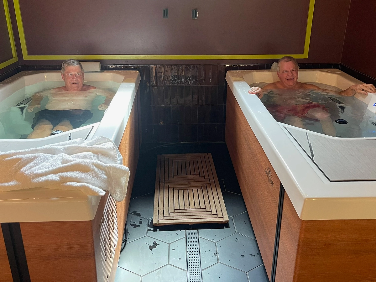 Two men soaking side by side in the cold plunge tubs at R3 Contrast